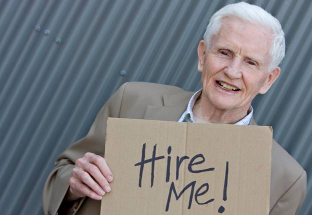 Older man with cardboard sign that says Hire Me - Age Discrimination